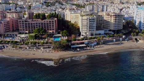 Drone-shot-panning-over-the-beach-front-of-Marbella,-Spain