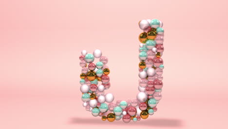 Letter-U-made-of-beads,-glass-balls,-pastel-pearls,-crystal-jewels-and-gold