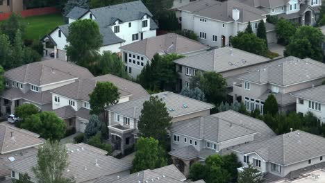 aerial view of a suburban neighborhood with multi-story houses and greenery