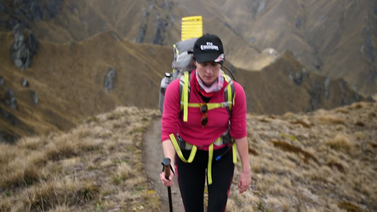 mujer caminando por las montañas en una aventura épica