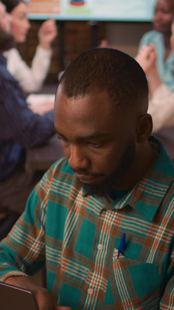 Vertical video: African american smiling employee working on laptop portrait, slowmotion