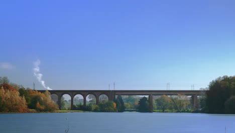 a time-lapse shot of a lake and a railway bridge