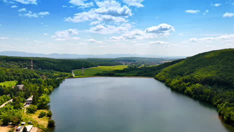 scenic lake view surrounded by nature. bright daylight captures a serene lake nestled among green hills and a clear blue sky, showcasing natural beauty