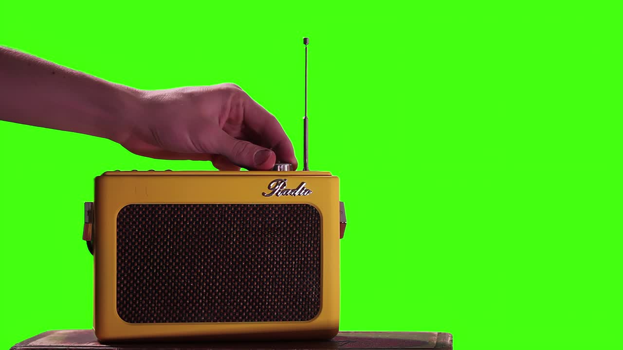 녹색 화면에서 휴대용 라디오 수신기를 켜는 남자 손. 근접. 4k 해상도.