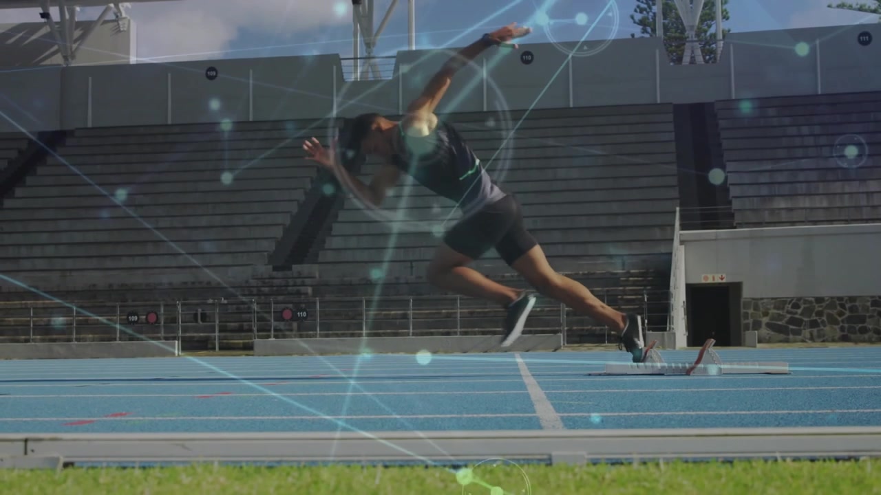 Sprinter inginocchiato sui blocchi di partenza su pista di atletica, che reagisce al segnale di partenza e si lancia nello sprint.