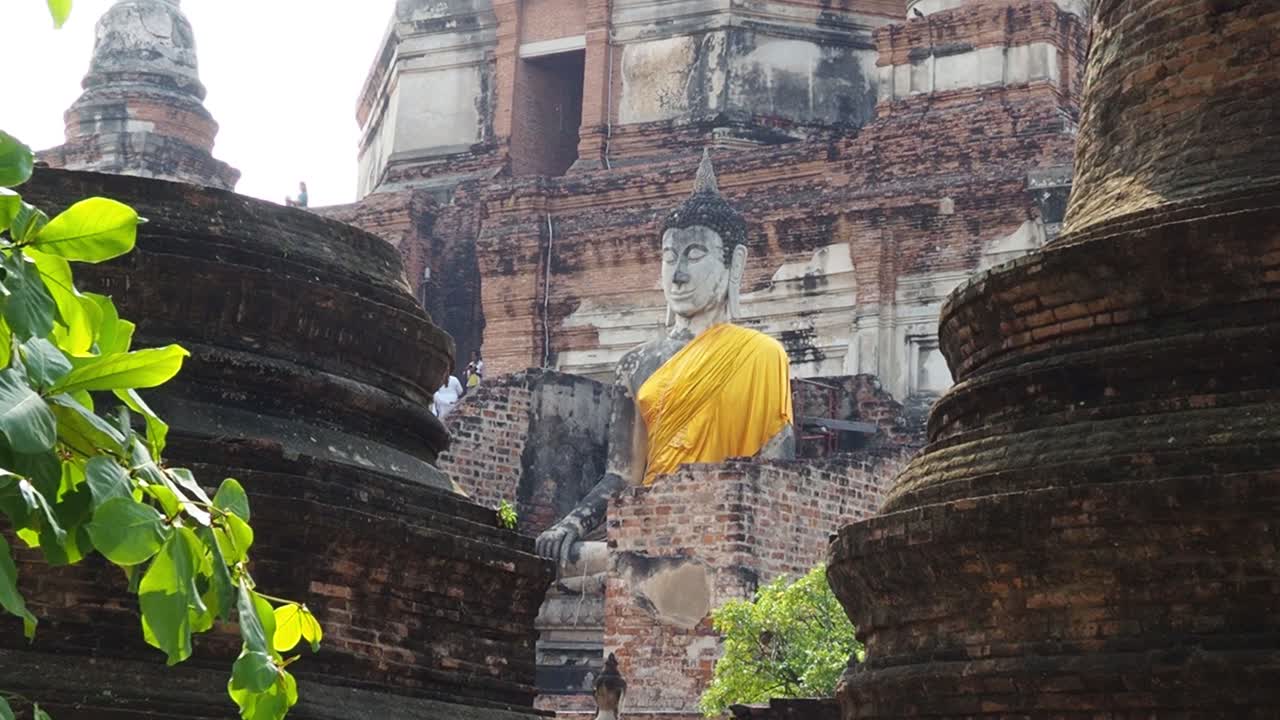 antigua estatua de buda envuelta en tela amarilla