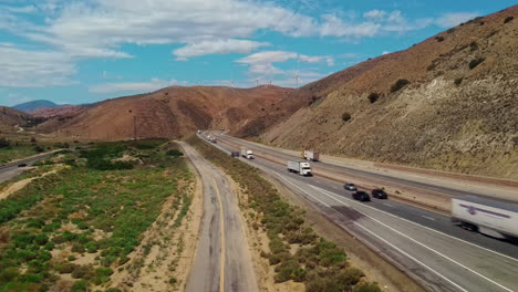 una carretera con camiones y coches entre colinas