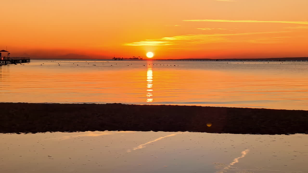 오렌지색 하늘과 반사와 함께 나브크 만에서 아침 해가 뜨는 이집트