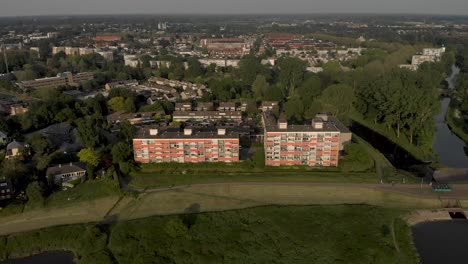 enfoque aéreo del paisaje urbano con sombrillas naranjas cerradas de edificios de apartamentos de gran altura a lo largo del río ijssel en un lento movimiento hacia atrás que revela el paisaje de las llanuras aluviales holandesas en zutphen