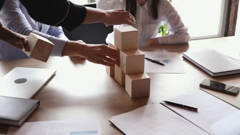 team people partners building tower of wooden blocks, close up