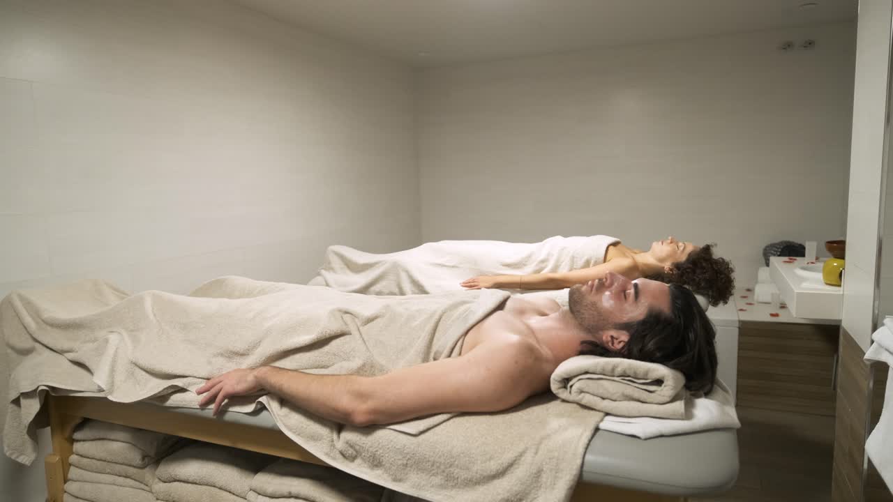 Mand og kvinde ligger på et massagebord.