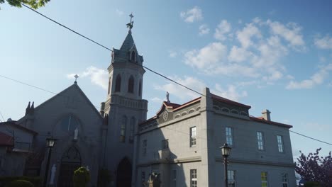 Architecture-of-the-Catholic-Church-of-Motomachi-district-in-Hakodate-Japan-on-a-sunny-day,-communication-wires