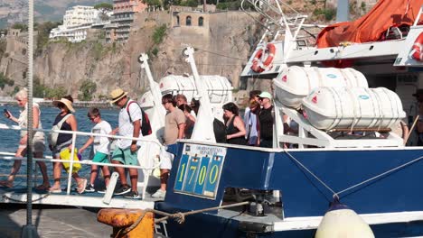 turistas que se suben a un barco en sorrento, italia