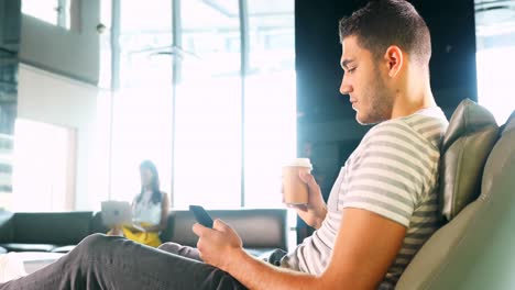ejecutivo masculino usando teléfono móvil mientras toma café 4k