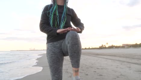 vrouw met vlechten die zijn benen op het strand verwarmt.