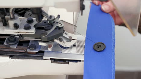 trabajadora que utiliza una máquina de coser industrial para botones