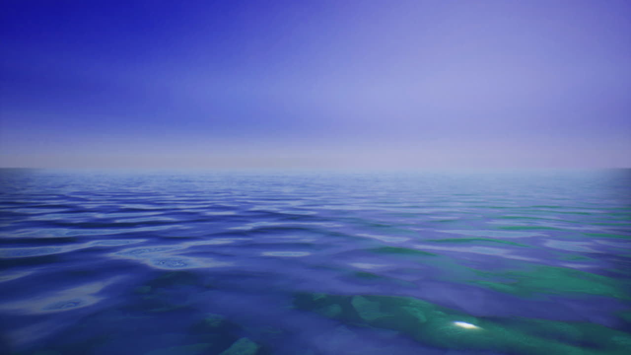 Vast calm ocean under a tranquil blue sky with soft waves