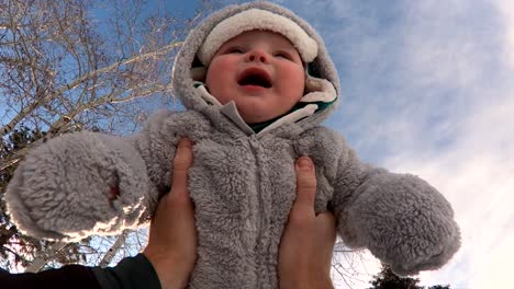 slo-mo shot of a happy child being tossed in the air