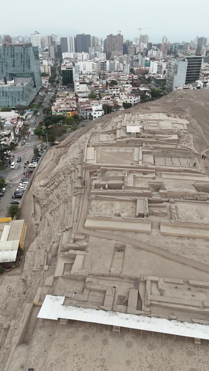 Huaca Pucllana ancient ruins amidst a modern city, Lima, Peru. Vertical drone footage