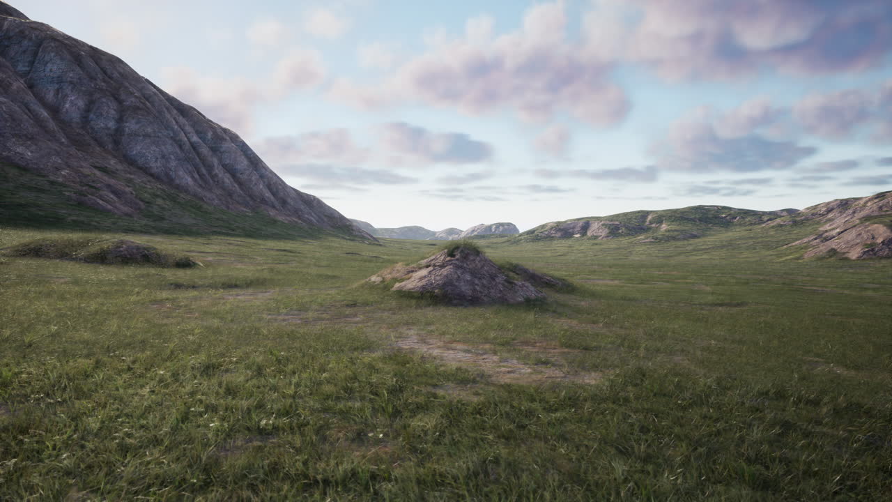 un amplio valle cubierto de hierba rodeado de montañas