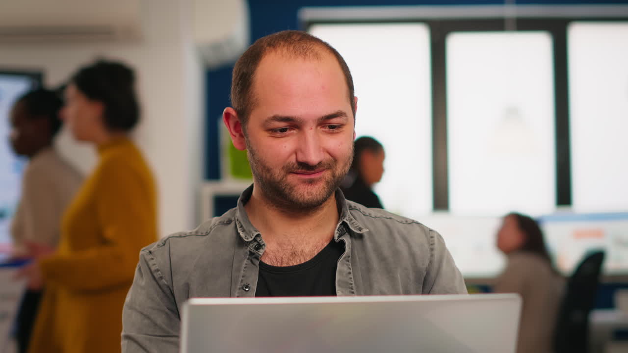 hombre de negocios entusiasta escribiendo un informe sentado en la mesa en un negocio moderno de puesta en marcha