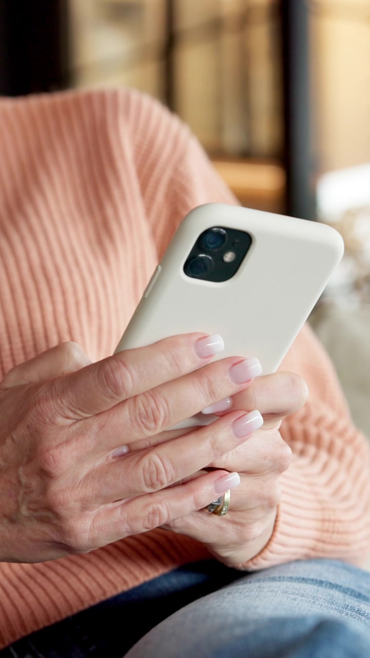 Donna matura che usa lo smartphone mentre si rilassa