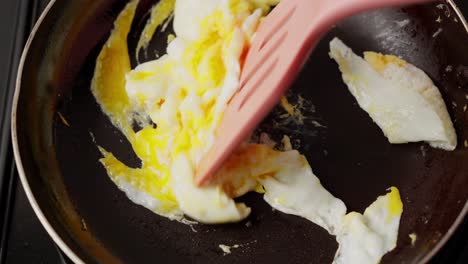 cooking scrambled eggs in frying pan. closeup shot