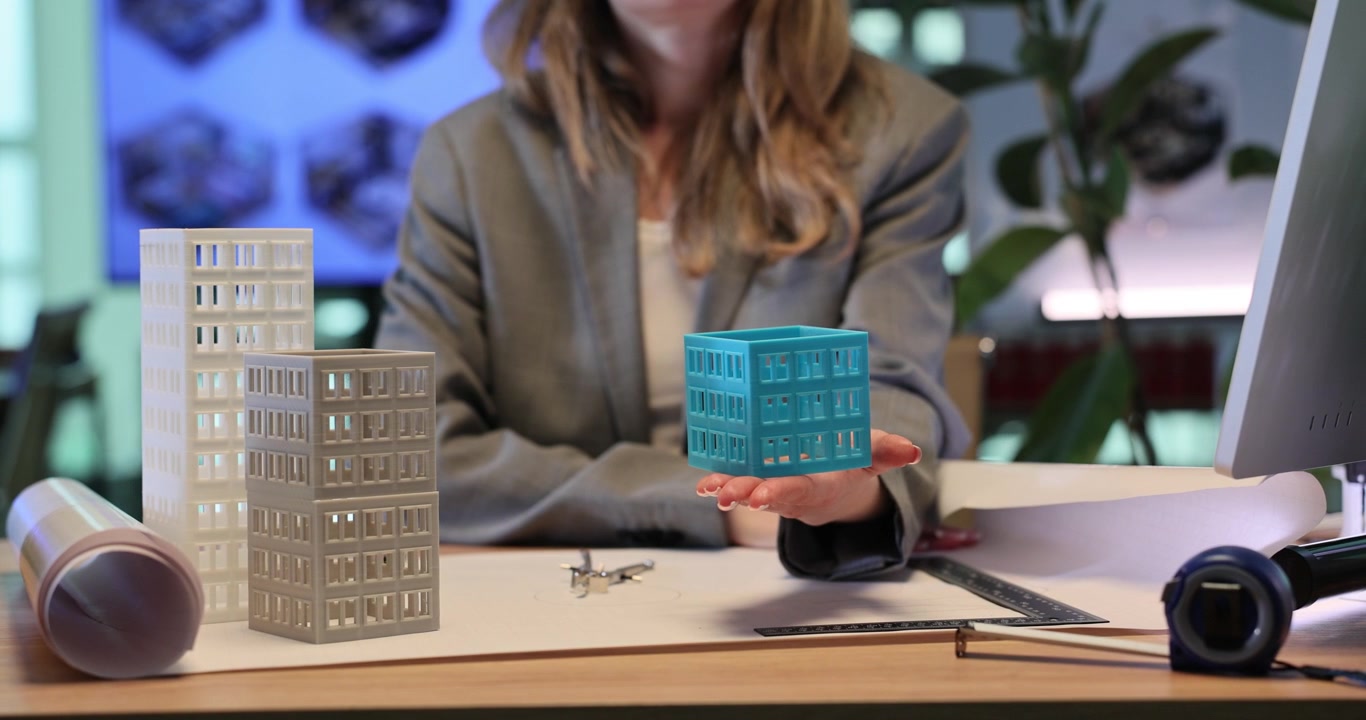 Architectural designer shows toy model of multistory building