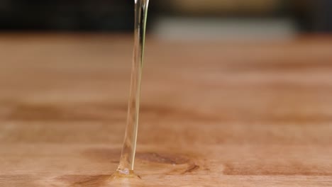 Brown-egg-being-cracked-on-butcher-block-and-spilling-out-egg-whites-in-slow-motion