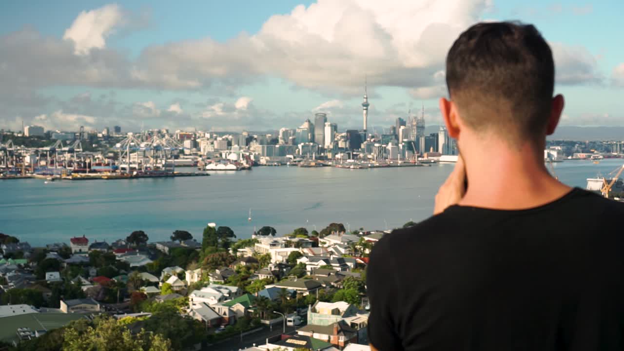 SLOWMO - Caucasian male from behind taking photo of Auckland downtown, New Zealand
