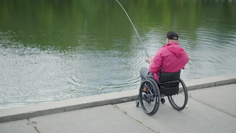 persona con discapacidad física que utiliza silla de ruedas para pescar en el muelle de pesca