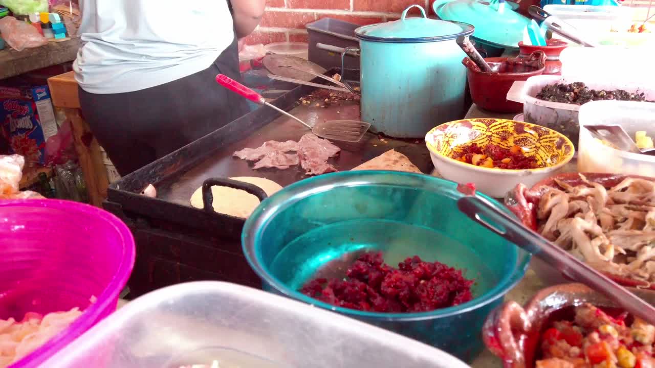 Backward slow motion view of colorful traditional ingredients at a Mexican street food stall. Close-up of food prep setup