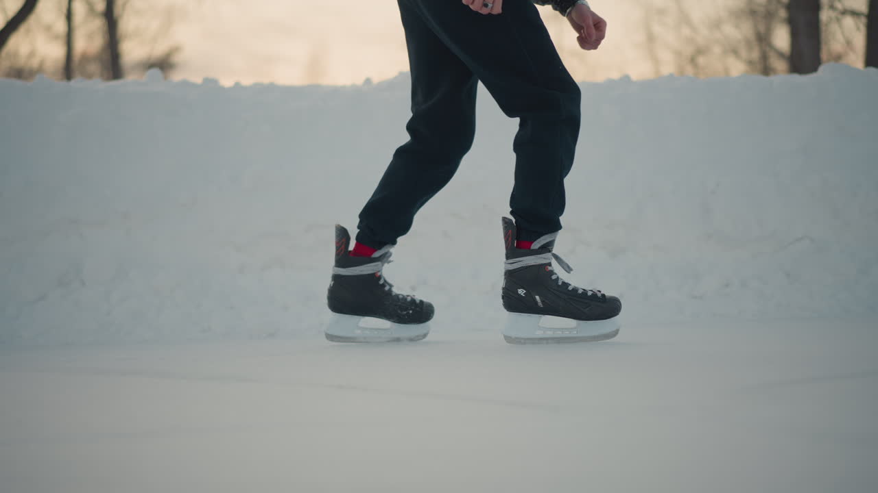 side view person skating on frozen lake ice surface tracks visible blur background trees hint winter sunset glow scene captures graceful glide motion and cold outdoor activity subtle