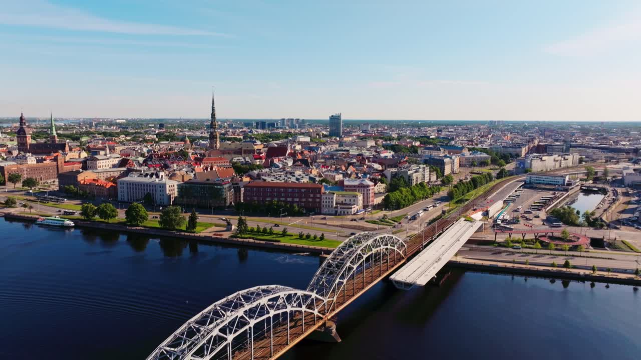 Drone pulls back, Riga old town skyline with bridges across Daugava River