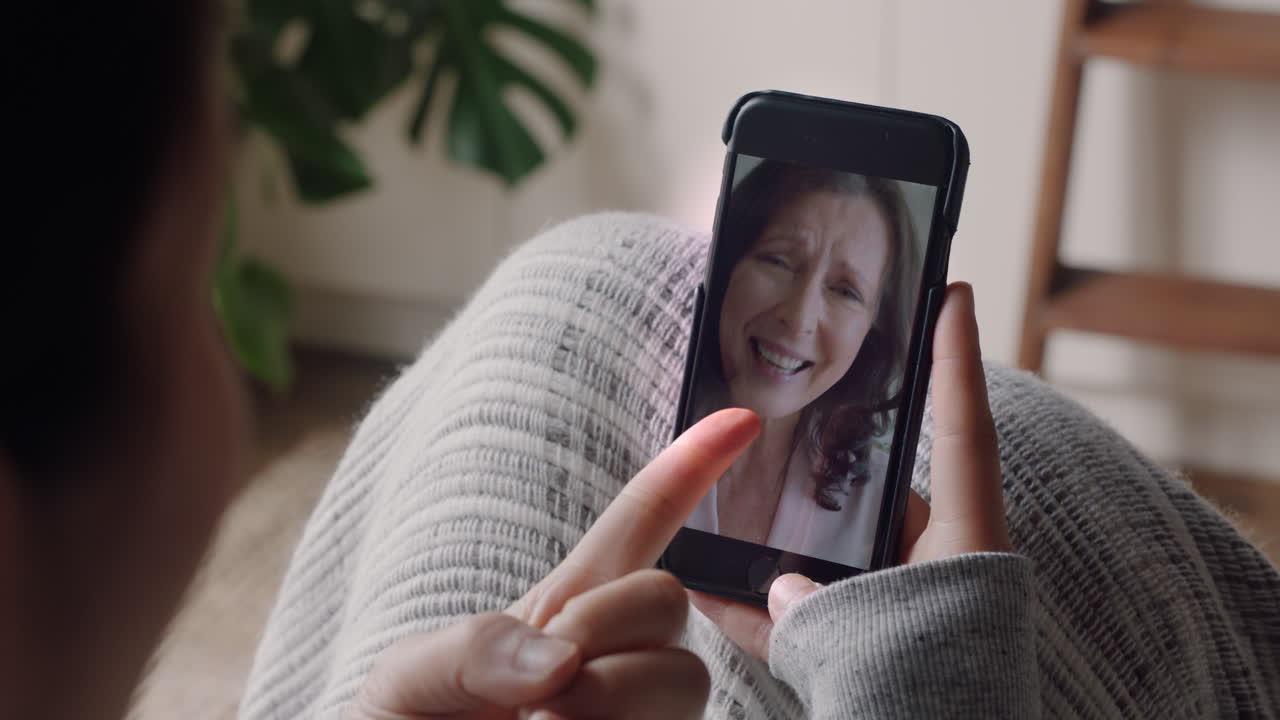 mujer joven teniendo video chat usando teléfono inteligente en casa hablando con su madre disfrutando de la conversación compartiendo estilo de vida en el teléfono móvil