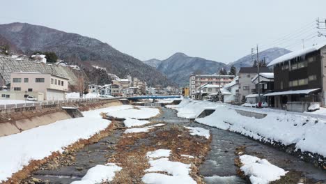 Snowy-River-Running-Through-Yudanaka-Onsen,-Yamanouchi,-Japan