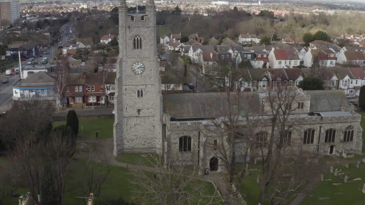 Uno stormo di uccelli che vola due volte intorno a un drone e una chiesa a Southend-on-Sea con abitazioni sullo sfondo