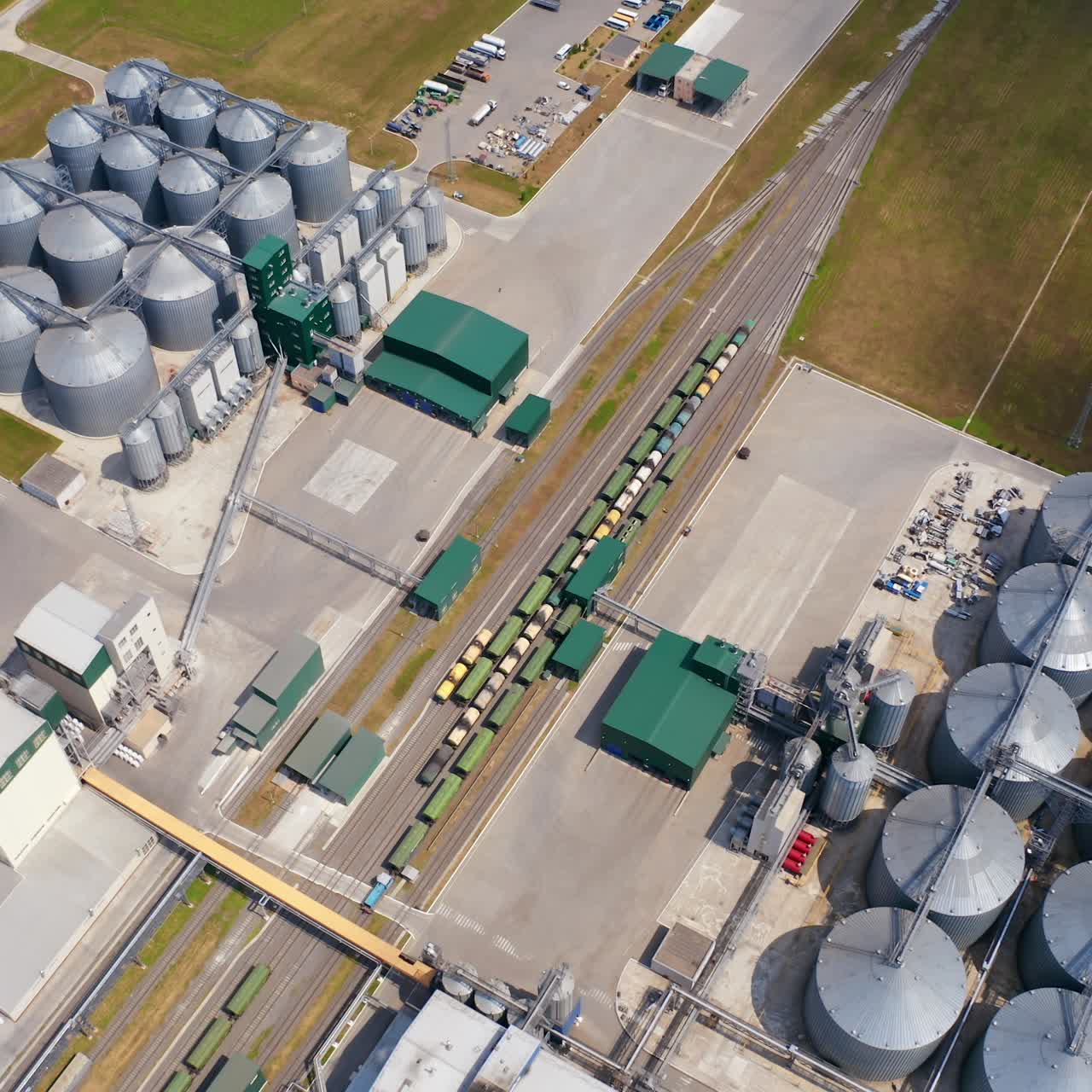 Agricultural silos on field. Grain elevators for storage and drying of cereals. Modern grain-drying complex. Orbital view from above