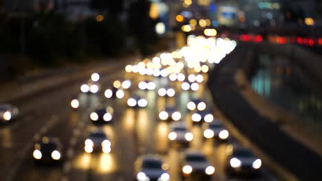 Blurred-from-view-of-car-lights-in-a-busy-traffic-highway-at-night,-close-up