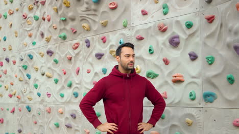 Un-Escalador-Respira-Pesadamente-Después-De-Hacer-Ejercicio-En-Un-Muro-De-Escalada-En-Un-Campo-Deportivo-Al-Aire-Libre,-Con-Las-Manos-En-La-Cintura