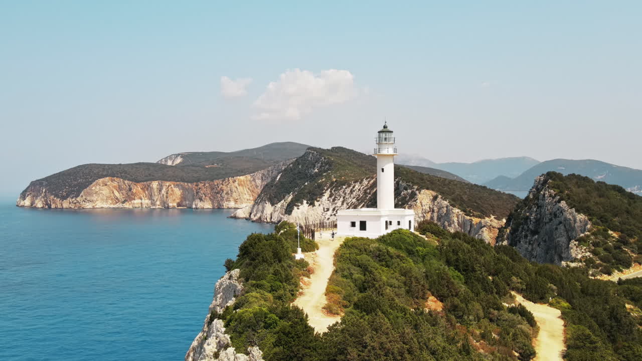 Aerial drone view of the Ionian Sea coast of Zakynthos, Greece. Rocky ridge with lighthouse and sparce vegetation, blue water