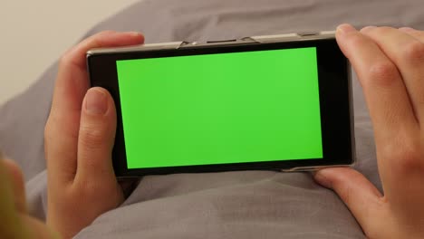 woman in bed surfing through internet pages on green screen mobile 4k 2160p ultrahd footage - female on greenscreen phone display 4k 3840x2160 uhd video