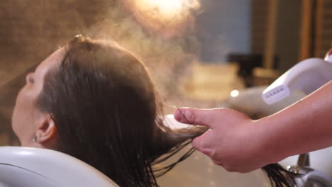 peluquero vaporizando el cabello de una mujer