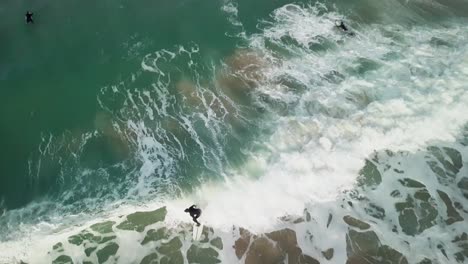 fistral beach in newquay, england - surfers having fun at the blue calm ocean - drone shot