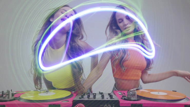 Identical twin female DJs dancing behind record turntables and ovelrayed disco lights