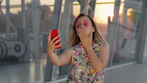 Tourist-girl-wearing-trendy-sunglasses-uses-phone.-Using-smartphone-for-call,-talk.-Trip,-tourism