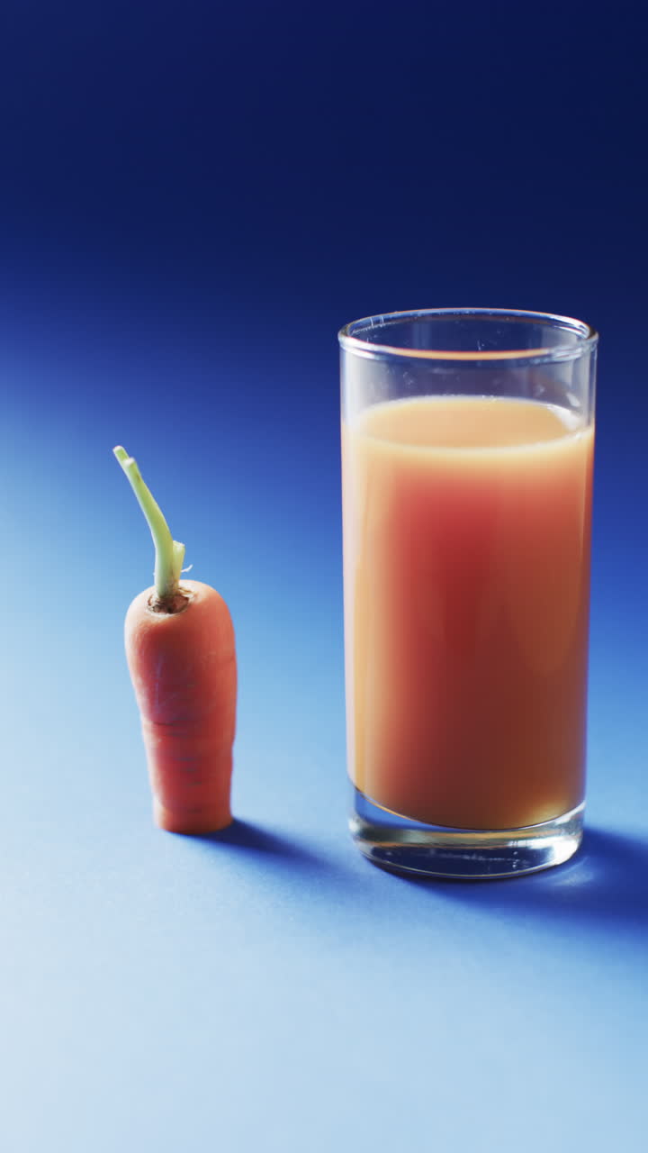 Video verticale di carota e succo di carota con spazio per il testo su sfondo blu