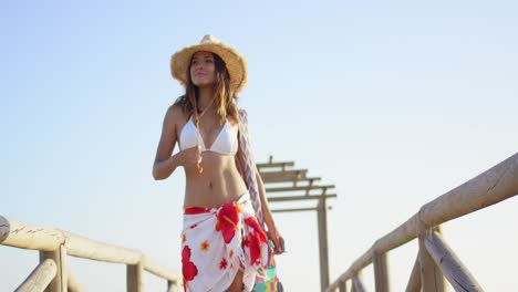 Low-angle-view-of-sultry-brunette-with-straw-hat