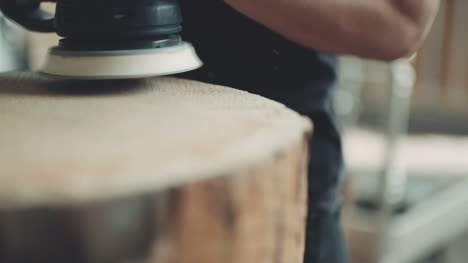 professional carpenter grinds wood in workshop 2