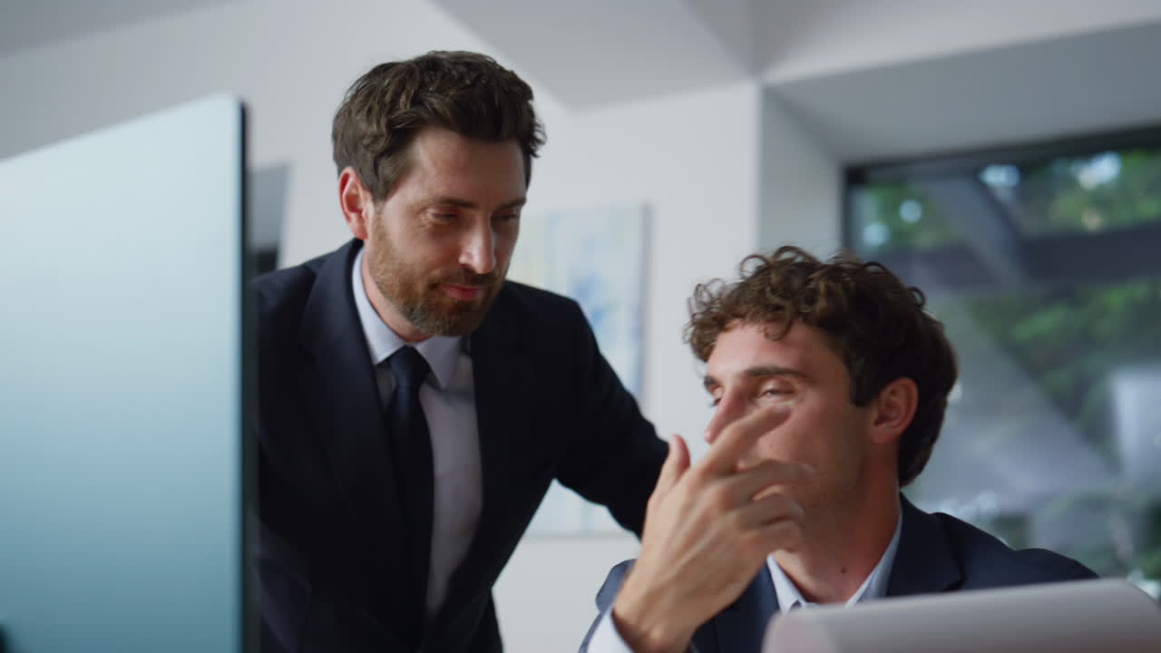 Two colleagues video calling laptop reading contract online in office closeup